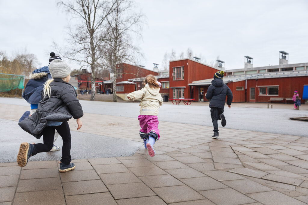 Skolbarn leker på skolgården.